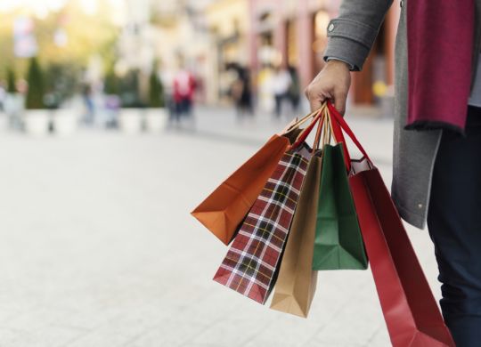 Man holding shopping bags with presents on the street